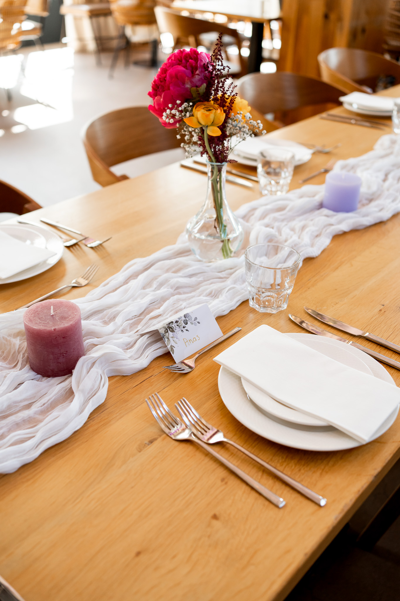 Elegante tafeldecoratie met bloemen, kaarsen en persoonlijke naamkaartjes