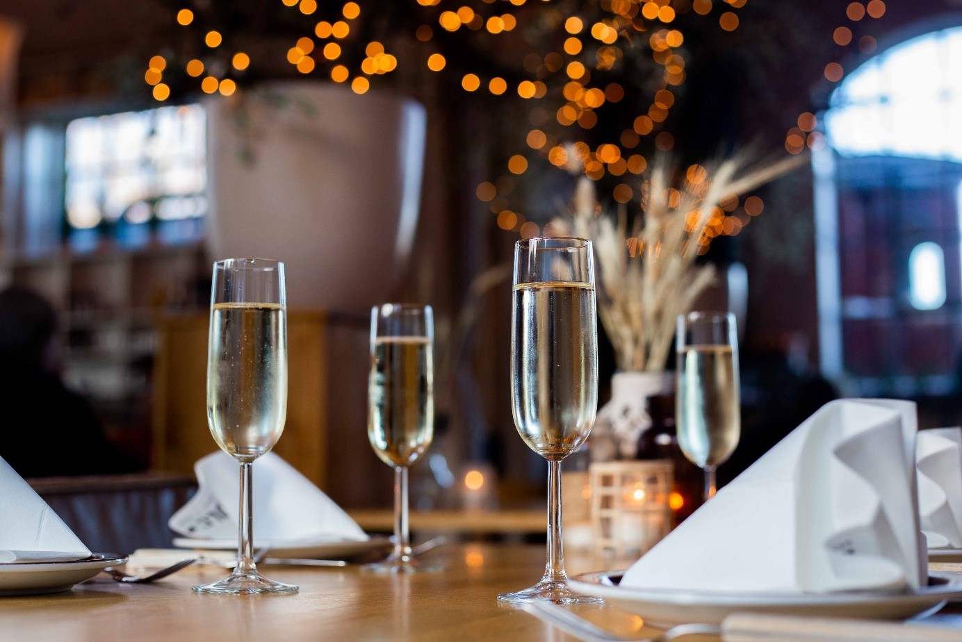 Feestelijk gedekte tafel met champagneglazen en sfeervolle verlichting tijdens een diner op een evenementenlocatie
